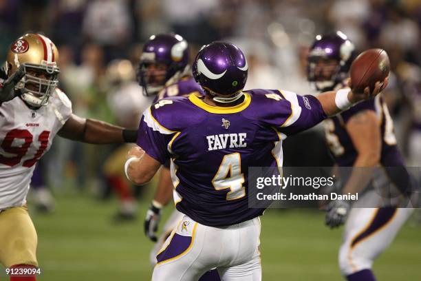Brett Favre of the Minnesota Vikings throws a pass as Ray McDonald of the San Francisco 49ers rushes at the Hubert H. Humphrey Metrodome on September...