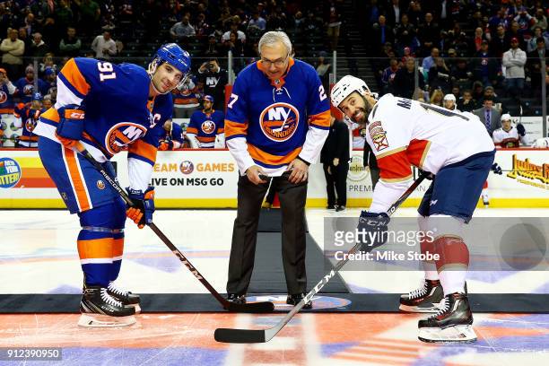Former New York Islander John Tonelli participates in a cermonial puck drop with John Tavares of the New York Islanders and Derek MacKenzie of the...