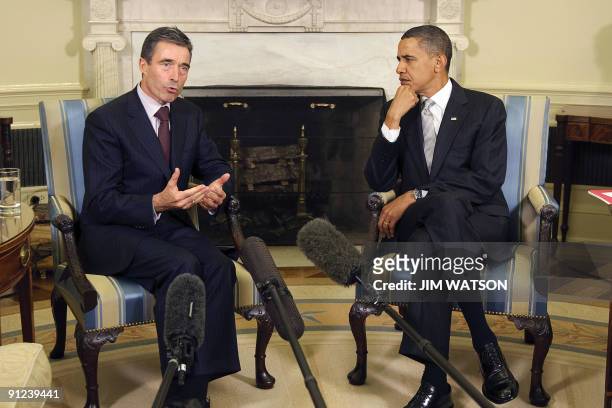 President Barack Obama looks on as NATO Secretary General Anders Fogh Rasmussen addresses the media during a meeting in the Oval Office of the White...
