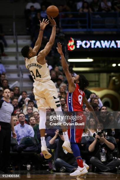 Giannis Antetokounmpo of the Milwaukee Bucks attempts a shot while being guarded by James Young of the Philadelphia 76ers in the fourth quarter at...