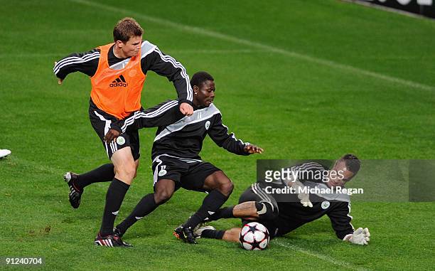 Alexander Madlung, Obafemi Martins and Diego Benaglio tussel for the ball during the VfL Wolfsburg training session at Old Trafford on September 29,...