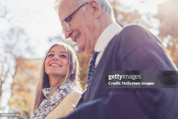 granddaughter and grandfather walking in the park - granddaughter stock pictures, royalty-free photos & images