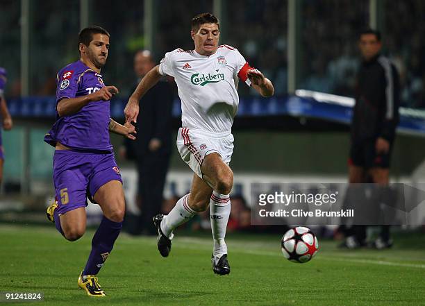 Steven Gerrard of Liverpool battles for the ball with Alessandro Gamberini of Fiorentina during the UEFA Champions League Group E match between...