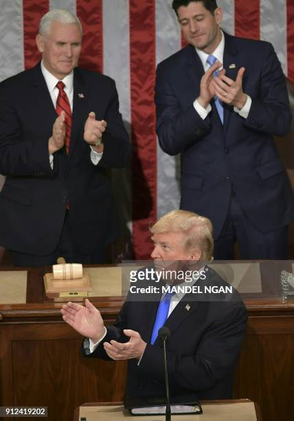 President Donald Trump delivers his State of the Union address as Vice President Mike Pence and Speaker of the House Paul Ryan clap at the US Capitol...