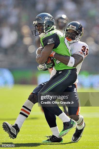 Nate Burleson of the Seattle Seahawks carries the ball as he is tackled by Charles Tillman of the Chicago Bears on September 27, 2009 at Qwest Field...