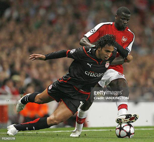 Diogo of Olympiacos is challenged by Arsenal's Ivory Coast player Emmanuel Eboue during a Champions League Group H match at The Emirates Stadium in...