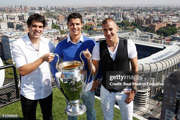 Kaka , Cristiano Ronaldo and Karim Benzema of Real Madrid poses with a European Cup and the Santiago Benabeu Stadium during a interview at Torre...
