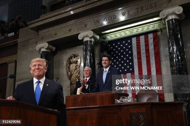 President Donald J. Trump stands at the podium as US Vice President Mike Pence and Speaker of the House US Rep. Paul Ryan look on during the State of...