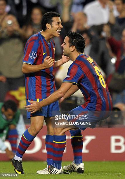 Barcelona's forward Pedro Rodriguez celebrates with teammate midfielder Xavi Hernandez after scoring a goal during the UEFA Champions League football...