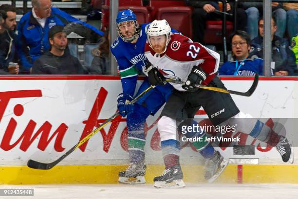Colin Wilson of the Colorado Avalanche checks Christopher Tanev of the Vancouver Canucks during their NHL game at Rogers Arena January 30, 2018 in...