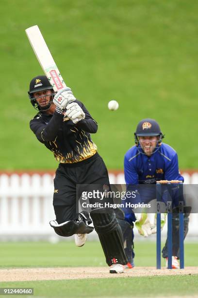 Peter Younghusband of the Firebirds bats while Derek de Boorder of the Volts looks on during the Ford Trophy match between the Wellington Firebirds...
