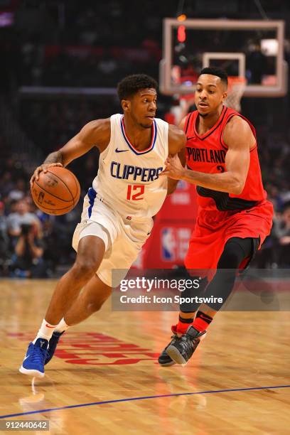 Los Angeles Clippers Guard Tyrone Wallace drives past Portland Trail Blazers Guard CJ McCollum during an NBA game between the Portland Trail Blazers...