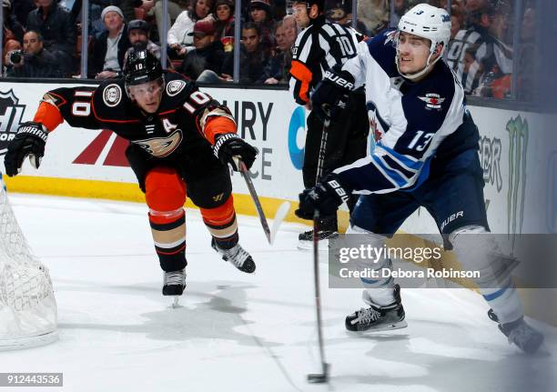 Brandon Tanev of the Winnipeg Jets passes the puck with pressure from Corey Perry of the Anaheim Ducks during the game on January 25, 2018 at Honda...