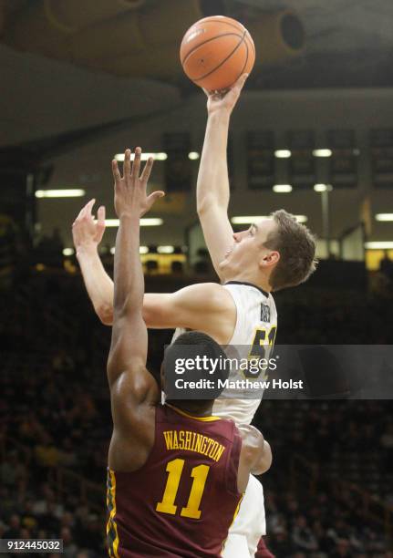 Forward Nicholas Baer of the Iowa Hawkeyes goes to the basket during the second half against guard Isaiah Washington of the Minnesota Gophers on...