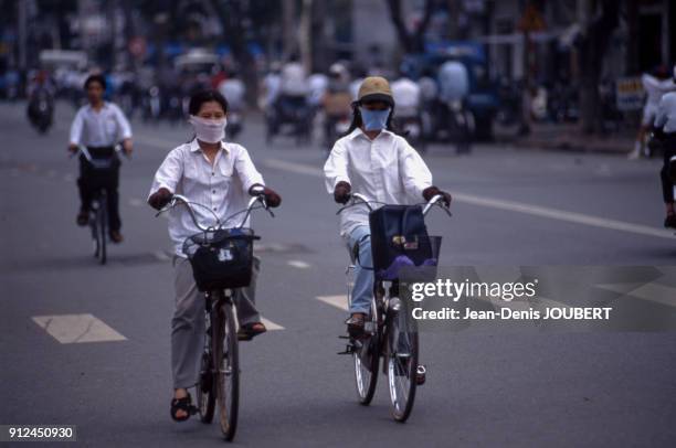 Cyclistes portant des masque anti-pollution a Ho-Chi-Minh-Ville , Viet Nam.