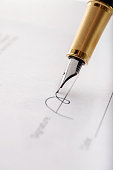 Close-up of gilded fountain pen signing contract, document. Vertical image.