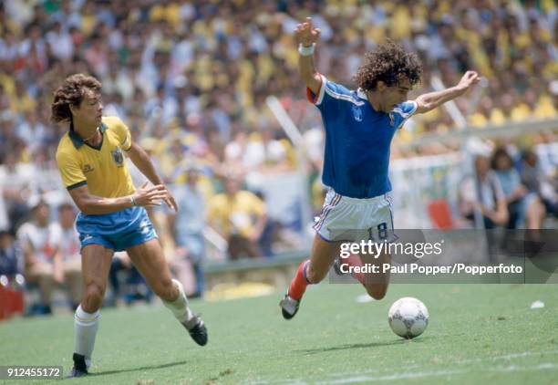 Dominique Rocheteau of France falling after a challenge by the Brazilian captain Edinho during the FIFA World Cup quarter final between France and...