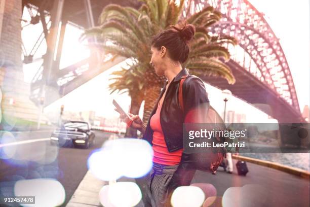 woman waiting a taxi ride in sydney - sydney harbour bridge night stock pictures, royalty-free photos & images