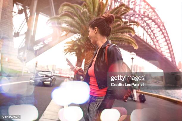 woman waiting a taxi ride in sydney - sydney night life stock pictures, royalty-free photos & images