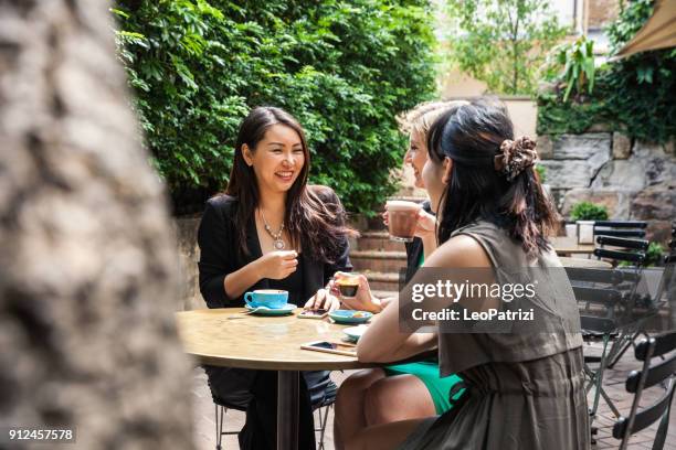 group of multi-ethnic women drinking and chilling in a cafe in sydney - café esplanada imagens e fotografias de stock