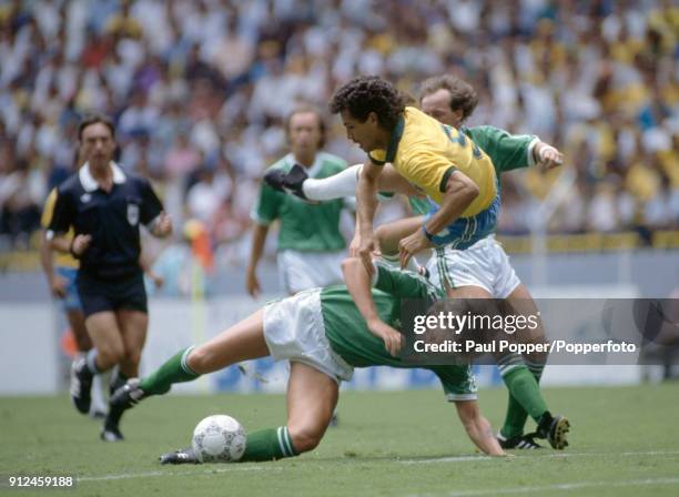 Brazilian striker Careca is upended by a tackle from Northern Ireland defender Alan McDonald during the FIFA World Cup match between Northern Ireland...