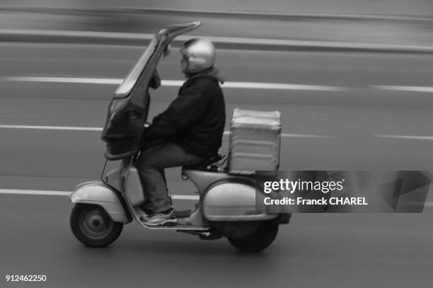 Coursier en scooter a Paris, France.