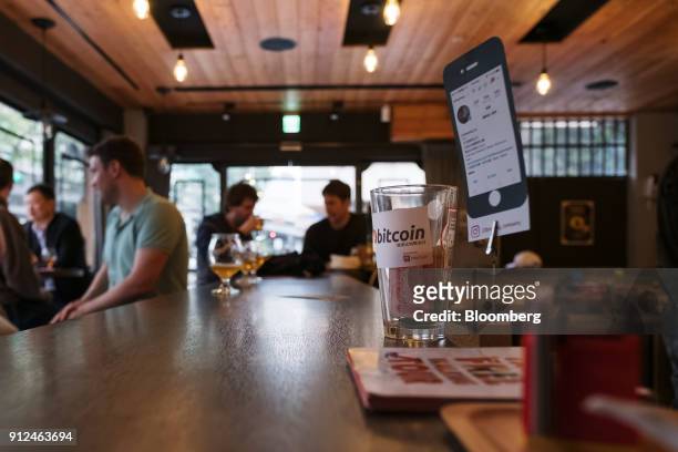 The Bitcoin logo is displayed on a tip jar inside the 23 cafe in Taipei, Taiwan, on Friday, Jan. 26, 2018. The half a billion dollar theft in Japan...