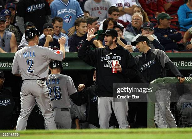 Aaron Hill and Adam Lind of the Toronto Blue Jays are congratulated by teammates after Lind hit a two run homer in the first inning against the...