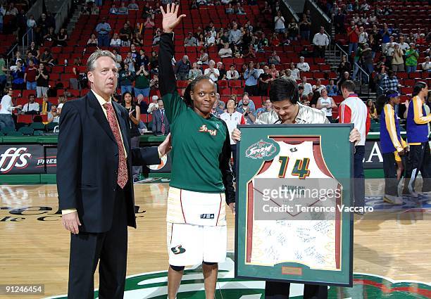 Shannon Johnson of the Seattle Storm waves to the fans after receiving a framed team jersey sign by her teammates, Johnson has decided to retire...