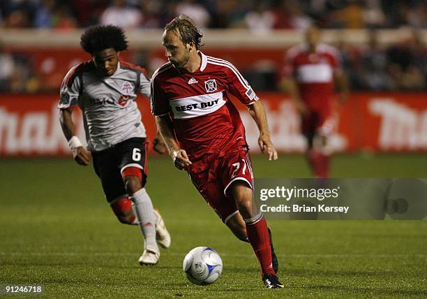 Justin Mapp of the Chicago Fire moves the ball up the field as Julian de Guzman of Toronto FC defends during the second half at Toyota Park on...