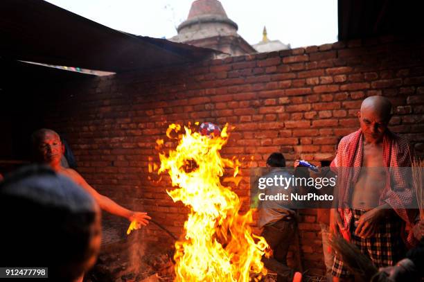 Nepalese Hindu devotee warm themselves after taking a holy bath during Last Day of Madhav Narayan Festival or Swasthani Brata Katha festival at...