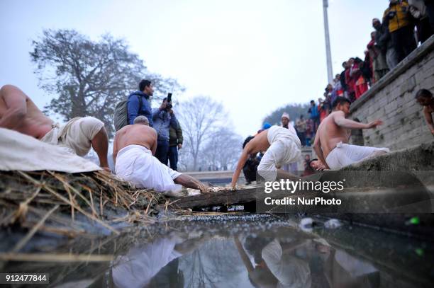 Nepalese Hindu devotees rolling procession around the Hanumante River during Last Day of Madhav Narayan Festival or Swasthani Brata Katha festival at...