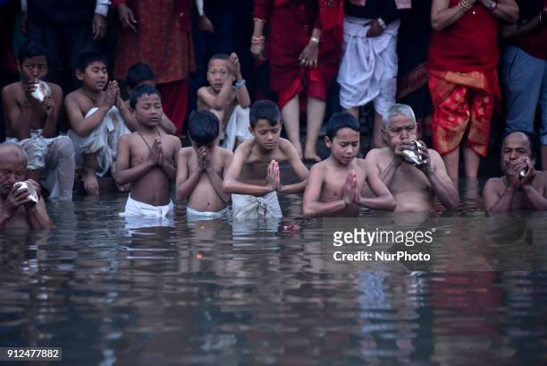Nepalese Hindu devotee offering ritual prayer during Last Day of Madhav Narayan Festival or Swasthani Brata Katha festival at Hanumante River,...