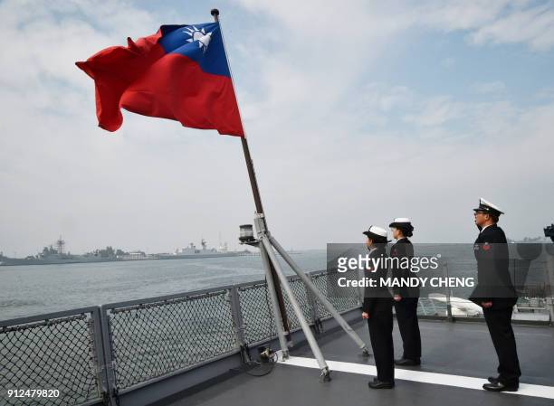 Taiwanese sailors salute the island's flag on the deck of the Panshih supply ship after taking part in annual drills, at the Tsoying naval base in...