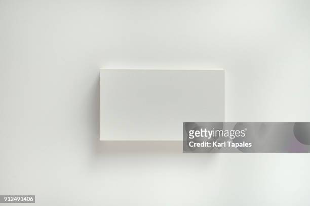 a stack of white blank calling cards - man in suit white background stock-fotos und bilder