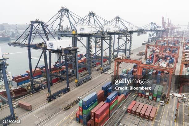 Remote-controlled gantry cranes, right, stand alongside other cranes, left, and shipping containers in Container Terminal 9, operated by Hong Kong...