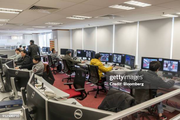 Employees operate remote-controlled cranes at a control room in Container Terminal 9, operated by Hong Kong International Terminal - a unit of CK...