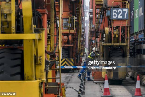 An employee stands next to a wheel of a remote-controlled gantry crane in Container Terminal 9, operated by Hong Kong International Terminal - a unit...