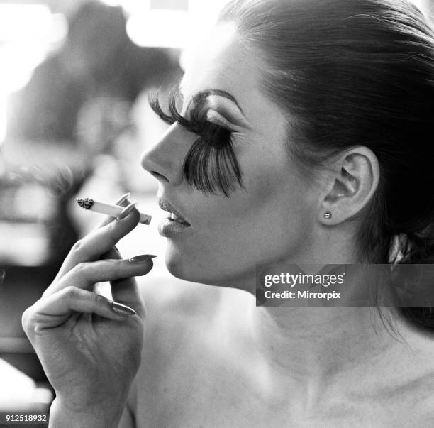 Woman wearing the longest eye lashes in the world, smoking a cigarette, 19th January 1968.