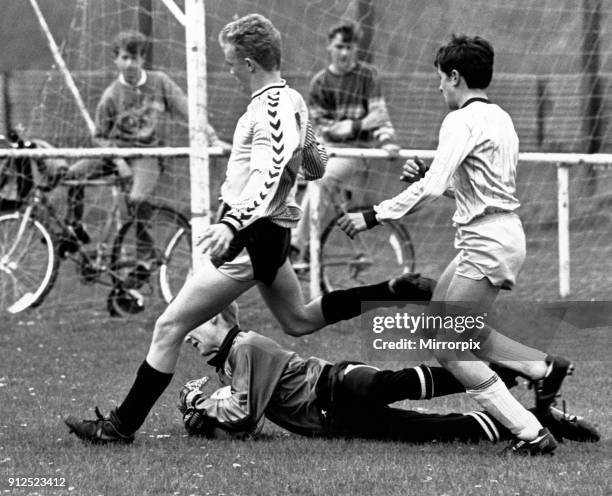 Stockton West End keeper Mark Woolnough dives at the feet of Michael Bates to rescue his defence in the North Riding Under 14s Minor Cup Final at...