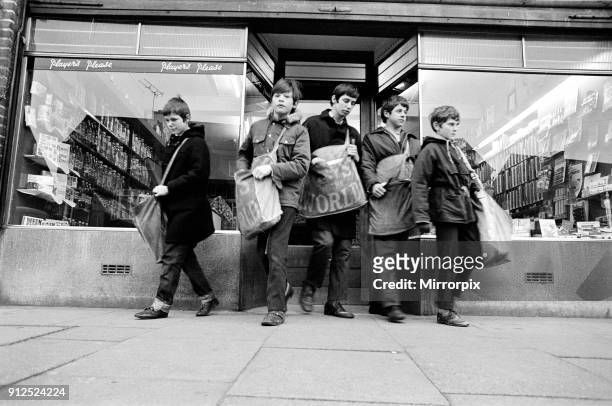 Newspaper round boys leaving the newsagents with their newspapers, ready for delivery, 18th April 1970.