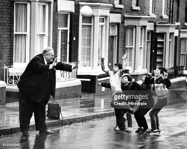 Cyril Smith, Liberal Member of Parliament for Rochdale playing football with a group of young boys in a street. Dingle, Liverpool, 13th April 1985.