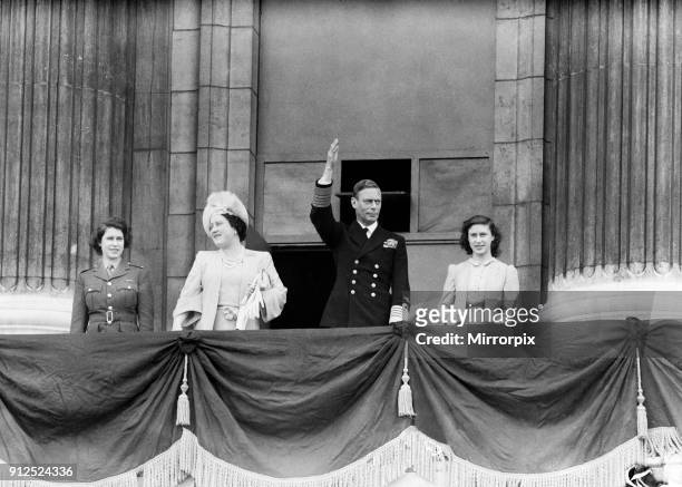 Day celebrations in London at the end of the Second World War. King George VI waves to the crowd from the balcony at Buckingham Palace during the...