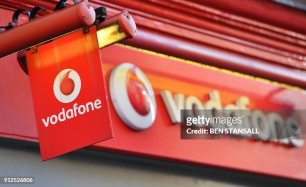 The logo of British mobile phone giant Vodafone welcomes visitors at their retail shop in central London on January 30, 2018.