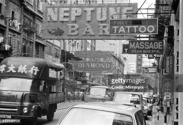 Traffic and signs advertising night clubs, tattoo and massage parlours seen here on Lockhart Road, Wanchai, Hong Kong. September 1974.