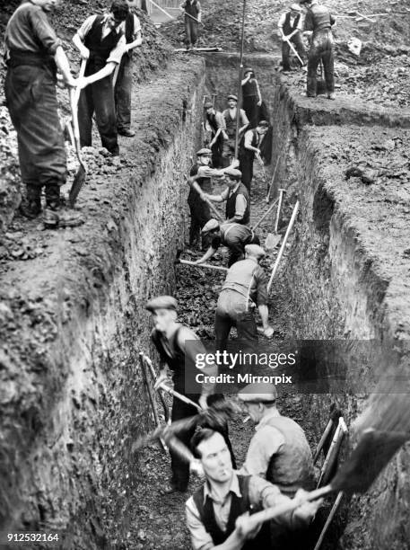 Men digging deep trenches in Birkenhead Park, which will become shelters. Birkenhead, Merseyside, 28th September 1938.