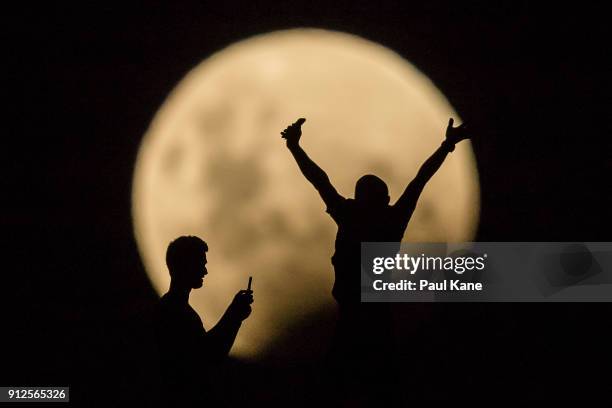 Photo Illustration showing people taking photos of the Super moon on January 31, 2018 in Lancelin, Australia. Last seen from Australia in December...