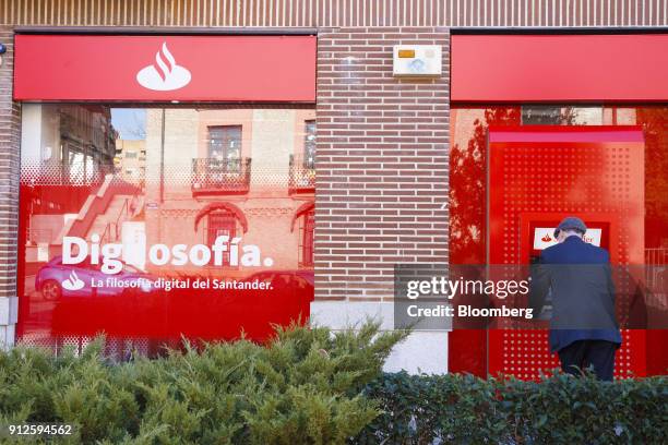 Customer uses an automated teller machine outside a Banco Santander SA bank branch as Spain's largest lender reports fourth quarter earnings in...