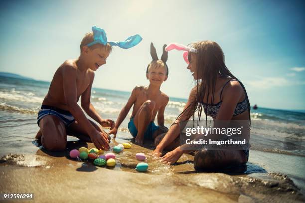 kinderen spelen in zee tijdens pasen - easter beach stockfoto's en -beelden