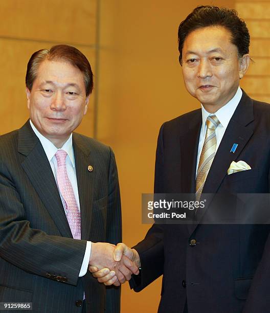 South Korean Foreign Minister Yu Myung-Hwan and Japanese Prime Minister Yukio Hatoyama shake hands prior to their meeting at Hatoyama's official...